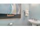 Stylish powder room with a pedestal sink, decorative sailboat art, and soft, blue-gray walls at 7071 Shooting Star Way, Myrtle Beach, SC 29579