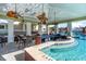 Outdoor pool bar with brick trim, ceiling fans, in-pool seating, and access to an additional seating area at 7079 Shooting Star Way, Myrtle Beach, SC 29579