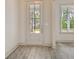 Bright entryway featuring a glass-paneled front door and light gray wood floors at 82 Bridgeview Rd., Georgetown, SC 29440