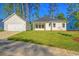 Exterior view of a home, featuring a manicured lawn, a detached garage, and an open-air patio at 82 Bridgeview Rd., Georgetown, SC 29440
