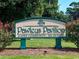 Pawleys Pavilion gated community sign nestled among greenery, denoting a private and secure neighborhood at 999 Algonquin Dr. # E, Pawleys Island, SC 29585