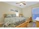 Bright bedroom with a queen-sized and twin-sized bed featuring floral bedding and a ceiling fan at 1009 World Tour Blvd. # 103, Myrtle Beach, SC 29579