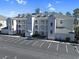 Exterior of condo building showing facade, balconies, and parking area on a sunny day at 1009 World Tour Blvd. # 103, Myrtle Beach, SC 29579