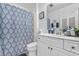 Bright bathroom features a white vanity, toilet, and blue patterned shower curtain at 117 Butkus Dr. # 1, Myrtle Beach, SC 29588
