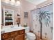 Well-lit bathroom with a wooden vanity, palm tree shower curtain, and a fresh, clean ambiance at 120 Henry Middleton Blvd., Myrtle Beach, SC 29588