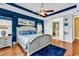 Bedroom with dark blue accent wall, ceiling fan, and elegant decor and furnishings at 120 Henry Middleton Blvd., Myrtle Beach, SC 29588