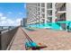Beachfront terrace with ocean views, lounge chairs and a cornhole game at 1210 N Waccamaw Dr. # 212, Garden City Beach, SC 29576