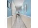 Well-lit hallway with blue walls, leading to a bright living area with ocean view at 1210 N Waccamaw Dr. # 212, Garden City Beach, SC 29576