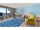 Bright living room with a patterned blue rug and comfortable couch near sliding glass doors to oceanfront balcony at 1210 N Waccamaw Dr. # 212, Garden City Beach, SC 29576