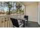 Cozy outdoor seating area on a covered balcony with wooded views at 1220 River Oak Dr. # 22C, Myrtle Beach, SC 29579