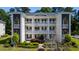 Three-story condo building with white siding, black shutters, and well-manicured landscaping at 1220 River Oak Dr. # 22C, Myrtle Beach, SC 29579