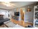 Open living room features wood floors, a large TV, and views into the dining area and hallway at 1301 Pridgen Rd. # 1101, Myrtle Beach, SC 29577