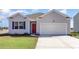 Charming single-story home featuring a red front door, light gray siding, and an attached two-car garage at 1454 Porchfield Dr., Conway, SC 29526