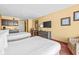 Comfortable room with two beds, a small dining table, and entertainment center at 1501 S Ocean Blvd. # 1005, Myrtle Beach, SC 29577