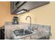 Close-up of wet bar area featuring a modern faucet, granite countertop, and coffee maker at 1501 S Ocean Blvd. # 1005, Myrtle Beach, SC 29577