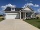Charming single-Gathering home featuring a two-car garage and well-manicured lawn against a blue sky at 155 Joyce Dr, Longs, SC 29568