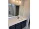 Bathroom vanity featuring white countertop, dark blue cabinets, mirror, and chrome fixtures at 180 Glengrove Lane, Murrells Inlet, SC 29576