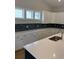 Kitchen with white cabinetry, designer backsplash, and stainless steel sink with modern faucet at 180 Glengrove Lane, Murrells Inlet, SC 29576