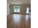 Open-concept living room with hardwood floors, a large window, and natural light at 180 Glengrove Lane, Murrells Inlet, SC 29576