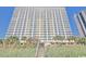 Exterior angle of a tall resort building with many balconies and palm trees at 2000 N Ocean Blvd. # 1509, Myrtle Beach, SC 29577