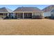 Backyard view of house featuring screened in porch and landscaping at 2049 Oxford St., Myrtle Beach, SC 29577