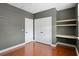 Bedroom with hardwood floors, gray walls, two white doors, and floating wooden shelves at 2049 Oxford St., Myrtle Beach, SC 29577