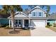 Charming two-story home with a well-manicured lawn, blue shutters, and a welcoming front porch at 2049 Oxford St., Myrtle Beach, SC 29577