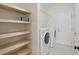 Bright laundry area with a washer and dryer and several wooden storage shelves at 2049 Oxford St., Myrtle Beach, SC 29577