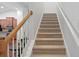 Carpeted staircase with white railings and natural wood accents leading to the upper level at 2049 Oxford St., Myrtle Beach, SC 29577
