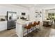 Modern kitchen with stainless steel appliances, white cabinets, granite counters, and adjacent open living space at 264 Warner Crossing Way, Loris, SC 29569