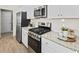 Well-lit kitchen with stainless steel appliances, white cabinets and backsplash, and granite countertops at 264 Warner Crossing Way, Loris, SC 29569
