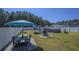 Expansive backyard area offering a table under an umbrella, firepit, and pool for ultimate relaxation and outdoor entertainment at 304 Carolina Springs Ct., Conway, SC 29527