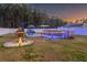 Backyard featuring a firepit, pool and blue LED lights creating a serene ambiance for evening enjoyment at 304 Carolina Springs Ct., Conway, SC 29527