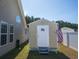 Tan storage shed featuring a white door with an American flag, enhancing outdoor storage capabilities at 304 Carolina Springs Ct., Conway, SC 29527