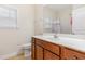 Well lit bathroom with a large mirror, white counter, toilet, and cherry colored cabinets at 321 Cabo Loop, Myrtle Beach, SC 29588