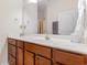 Well lit bathroom with a large mirror, white counter, and cherry colored cabinets at 321 Cabo Loop, Myrtle Beach, SC 29588