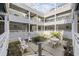 Enclosed multi-story condo courtyard with table, chairs and a small garden at 351 Lake Arrowhead Rd. # 131, Myrtle Beach, SC 29572