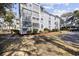 Multi-story condo building with light gray siding, mature landscaping, and shade trees at 351 Lake Arrowhead Rd. # 131, Myrtle Beach, SC 29572