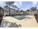 Community pool with a metal fence, ladder, and gray buildings with tall trees nearby at 351 Lake Arrowhead Rd. # 131, Myrtle Beach, SC 29572