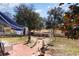 Inviting backyard with a brick patio, fire pit, and white picket fence, perfect for relaxing outdoors at 356 Boxcar Dr., Longs, SC 29568