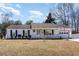 Charming one-story home with a welcoming front porch, well-manicured lawn, and attached garage at 356 Boxcar Dr., Longs, SC 29568
