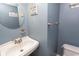 Powder room with round mirror and light blue walls, enhanced with beach decor at 4115 Little River Rd. # 4-F, Myrtle Beach, SC 29577