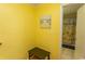 Yellow hallway with decor and a bench, leading to a bathroom at 4115 Little River Rd. # 4-F, Myrtle Beach, SC 29577