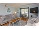 Bright living room offering a cozy atmosphere with stylish decor, comfortable seating and a TV for relaxation at 4115 Little River Rd. # 4-F, Myrtle Beach, SC 29577