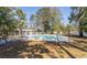 Community pool area with a manicured lawn, mature shade trees, and privacy fence at 4115 Little River Rd. # 4-F, Myrtle Beach, SC 29577