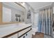 Bathroom with a framed mirror, vanity, toilet, and tub-shower combo with curtain at 4350 Intercoastal Dr. # 2301, Little River, SC 29566