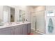 Bright bathroom featuring a double sink vanity, framed mirrors, and glass enclosed shower at 551 Firouz Dr, Longs, SC 29568