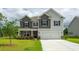 Charming two-story home with a well-manicured lawn and inviting stone accents and a two car garage at 6007 Forest Dell Ct, Myrtle Beach, SC 29579