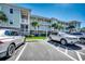 Condo exterior featuring multiple stories, white railings, landscaping, and parking at 6253 Catalina Dr. # 1711, North Myrtle Beach, SC 29582