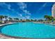Expansive community pool with clear blue water, palm trees, lounge chairs, and a central gazebo at 6253 Catalina Dr. # 1711, North Myrtle Beach, SC 29582